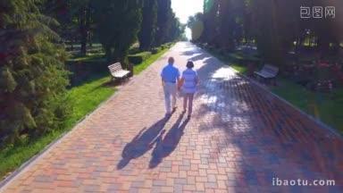 航拍的<strong>一对</strong>老年夫妇在夏日公园牵着手散步的画面